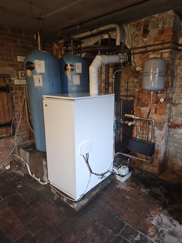 Basement plant room with Grant floor-standing boiler and hot water cylinders installed by APS