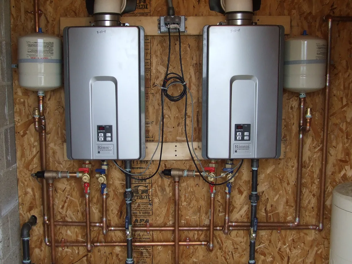 Two wall-mounted tankless gas water heaters with copper pipework