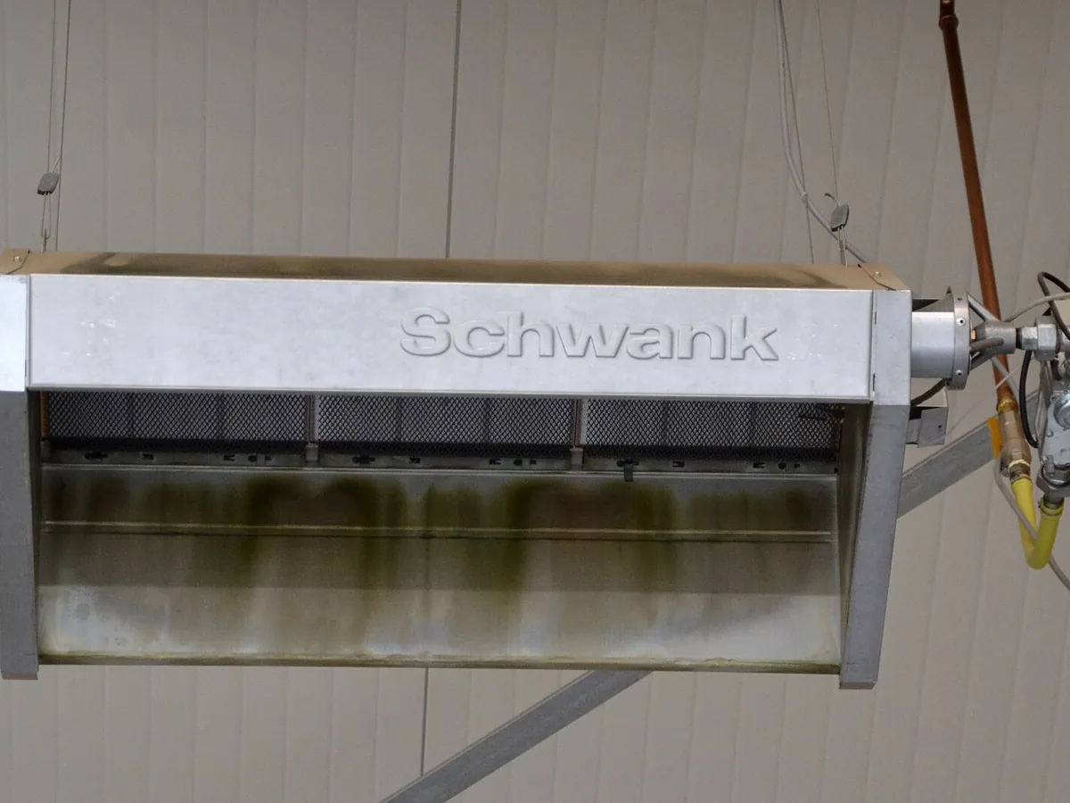 High-level gas radiant plaque heater suspended from an industrial ceiling